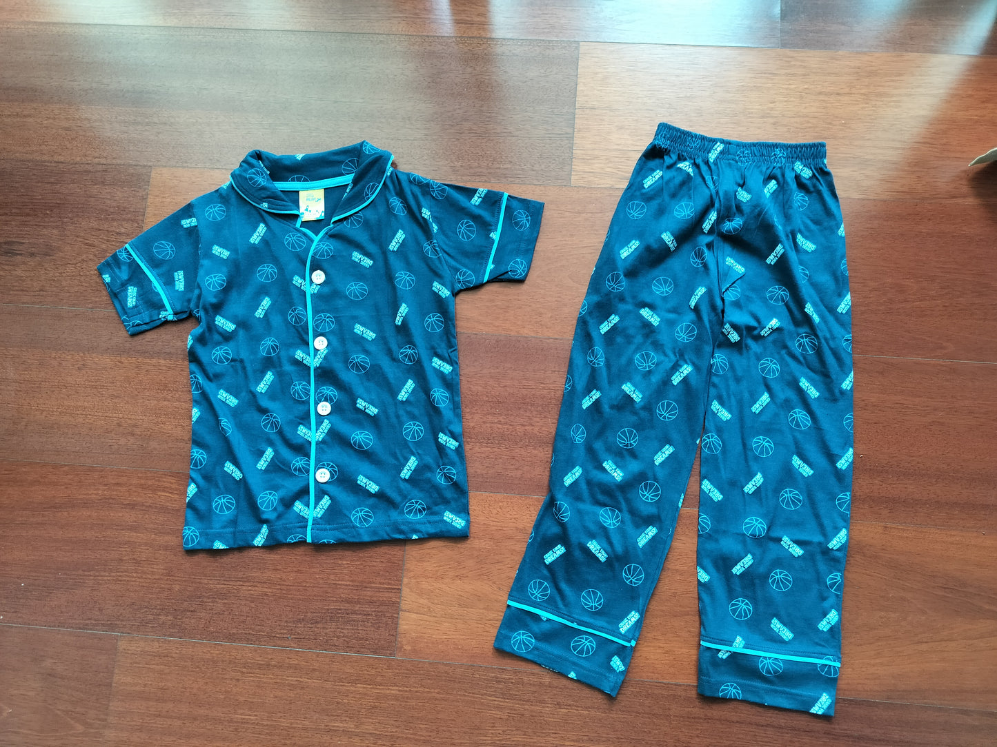 Blue children's pajama set with patterns on a wooden floor